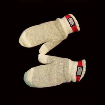 A pair of grey wool mittens with red and white cuffs on a black background