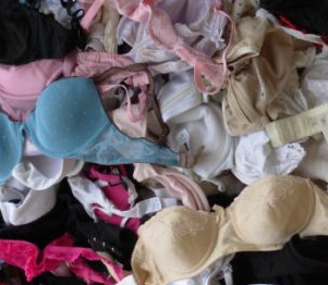 A pile of assorted bras and underwear in pink, blue, white and black