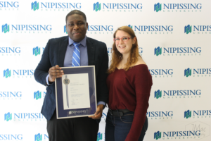 Guests and award recipients at the Dave Marshall Leadership Awards reception, posing in front of a Nipissing University backdrop
