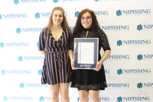 Guests and award recipients at the Dave Marshall Leadership Awards reception, posing in front of a Nipissing University backdrop