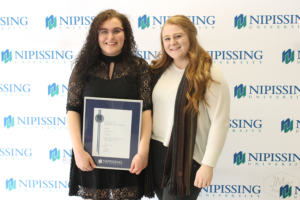Guests and award recipients at the Dave Marshall Leadership Awards reception, posing in front of a Nipissing University backdrop
