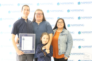 Guests and award recipients at the Dave Marshall Leadership Awards reception, posing in front of a Nipissing University backdrop