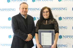 Guests and award recipients at the Dave Marshall Leadership Awards reception, posing in front of a Nipissing University backdrop
