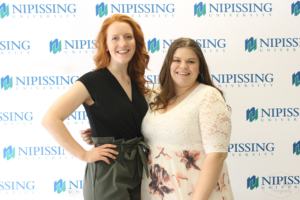 Guests and award recipients at the Dave Marshall Leadership Awards reception, posing in front of a Nipissing University backdrop