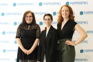 Guests and award recipients at the Dave Marshall Leadership Awards reception, posing in front of a Nipissing University backdrop