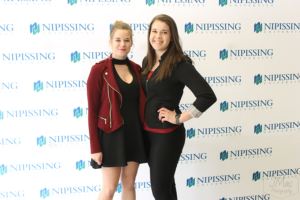 Guests and award recipients at the Dave Marshall Leadership Awards reception, posing in front of a Nipissing University backdrop