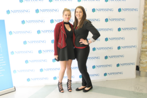 Guests and award recipients at the Dave Marshall Leadership Awards reception, posing in front of a Nipissing University backdrop