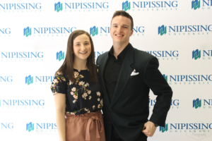 Guests and award recipients at the Dave Marshall Leadership Awards reception, posing in front of a Nipissing University backdrop