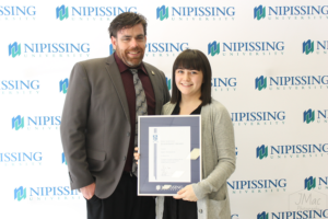 Guests and award recipients at the Dave Marshall Leadership Awards reception, posing in front of a Nipissing University backdrop