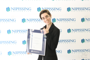 Guests and award recipients at the Dave Marshall Leadership Awards reception, posing in front of a Nipissing University backdrop