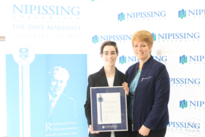 Guests and award recipients at the Dave Marshall Leadership Awards reception, posing in front of a Nipissing University backdrop