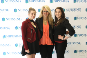 Guests and award recipients at the Dave Marshall Leadership Awards reception, posing in front of a Nipissing University backdrop