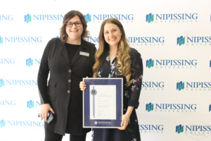 Guests and award recipients at the Dave Marshall Leadership Awards reception, posing in front of a Nipissing University backdrop