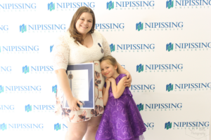 Guests and award recipients at the Dave Marshall Leadership Awards reception, posing in front of a Nipissing University backdrop