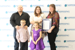 Guests and award recipients at the Dave Marshall Leadership Awards reception, posing in front of a Nipissing University backdrop