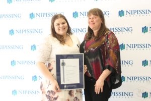 Guests and award recipients at the Dave Marshall Leadership Awards reception, posing in front of a Nipissing University backdrop