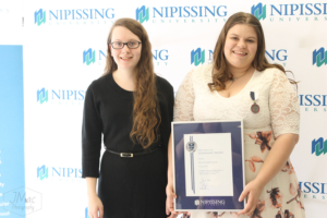 Guests and award recipients at the Dave Marshall Leadership Awards reception, posing in front of a Nipissing University backdrop
