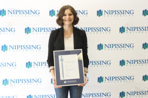 Guests and award recipients at the Dave Marshall Leadership Awards reception, posing in front of a Nipissing University backdrop